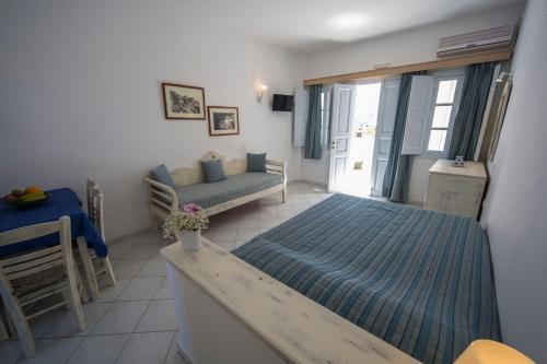 a bedroom with a bed and a couch in it at Ianthe Apartments & Villa in Oia