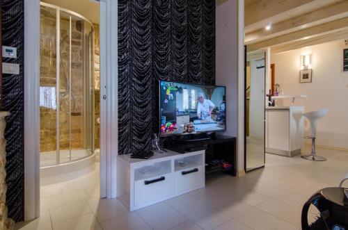 a living room with a television on a stand at Apartment Capo Family & Capo Studio -Old Town-Parking in Trogir