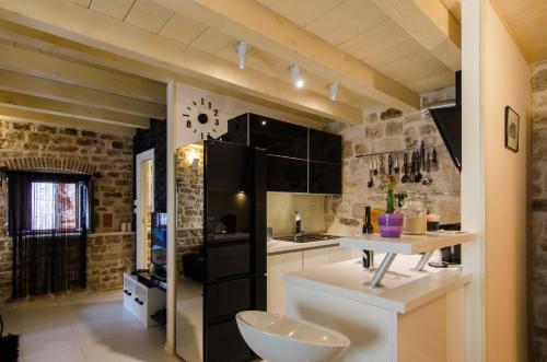 een keuken met een zwarte koelkast en een wastafel bij Apartment Capo Family & Capo Studio -Old Town-Parking in Trogir