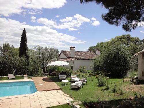 a backyard with a swimming pool and a house at Mas Les Micocouliers in Saint-Christol-lès-Alès