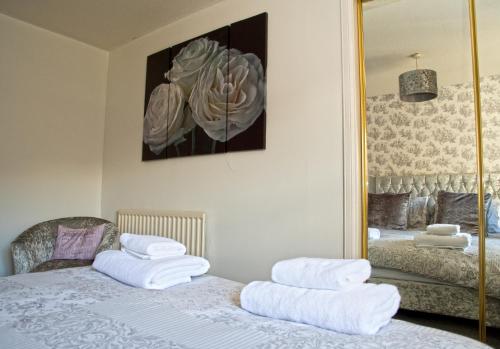a bedroom with a bed with white towels on it at No5 Ayr Beach - Coorie Doon Stays in Ayr