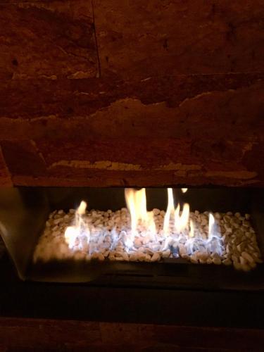a fire in a brick oven with flames at Mar y Luz in Koksijde