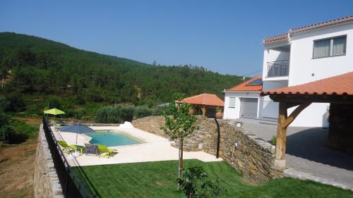 a villa with a swimming pool and a house at Casa da Ladeira, Turismo Rural in Estreito
