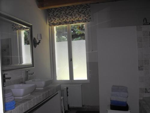 a bathroom with two sinks and two windows at Le Mas de Panier in Caderousse