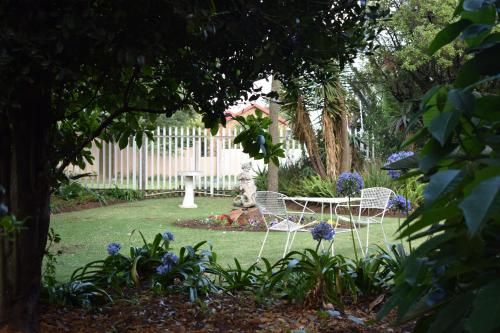 two chairs and a table in a garden at Moye Guest House in Benoni