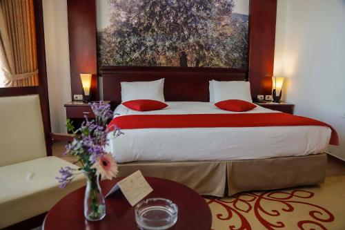 a hotel room with a large bed and a table at City Inn Palace Hotel in Ramallah
