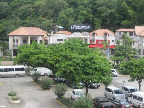 a parking lot with cars parked in front of buildings at McFarlane's Place in Ocho Rios