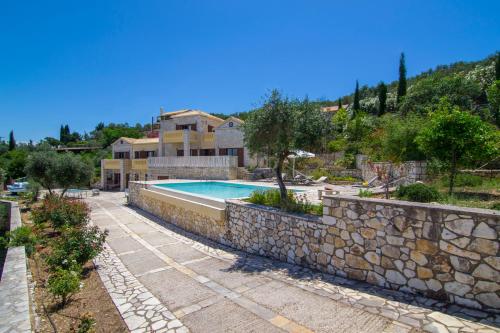 Willa z basenem i kamienną ścianą w obiekcie Villa Ionia w mieście Gaios