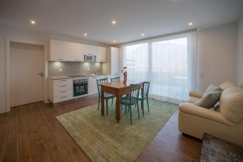 a kitchen and dining room with a table and a couch at Scarpapè in Giubiasco