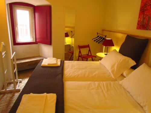 a bedroom with a bed and a window and a room at Casa da Rua Nova in Castelo de Vide