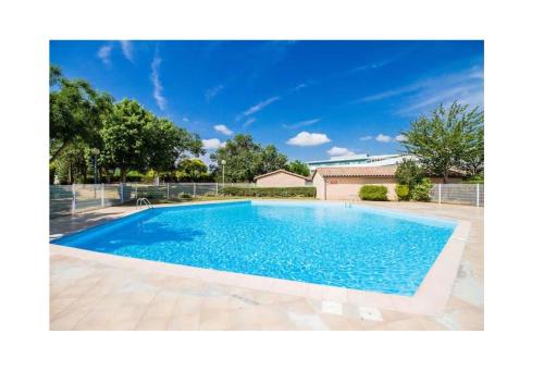 une grande piscine dans une cour avec une clôture dans l'établissement Appartement Contemporain proche Météo, Basso Cambo, EDF, Airbus & Thales, à Toulouse