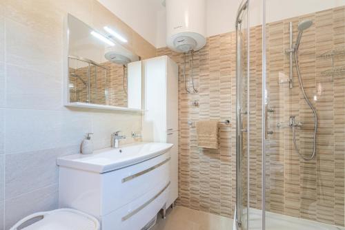 a bathroom with a toilet and a sink and a shower at Apartman Tea in Privlaka