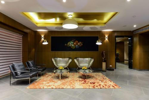 a lobby with two chairs and a glass table at Howard Johnson by Wyndham, Kolkata Airport in Kolkata