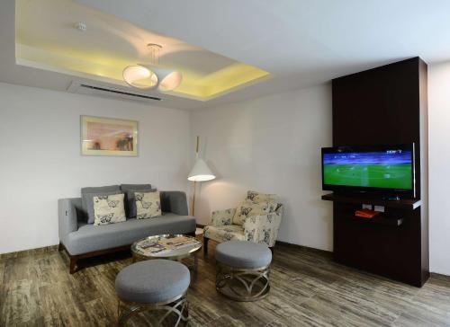 a living room with a couch and a flat screen tv at Howard Johnson by Wyndham, Kolkata Airport in Kolkata