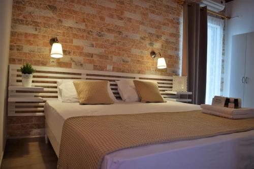 een slaapkamer met een bed en een bakstenen muur bij The Coast in Anaxos