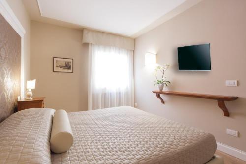 ヴェローナにあるLa Perla Apartmentのベッドルーム1室(ベッド1台、壁掛けテレビ付)