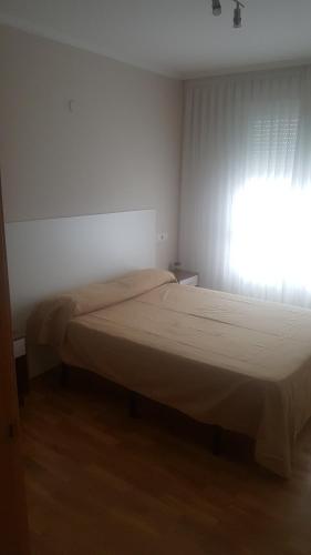 Schlafzimmer mit einem Bett und einem Fenster mit Vorhängen in der Unterkunft Costa do Castro in Foz