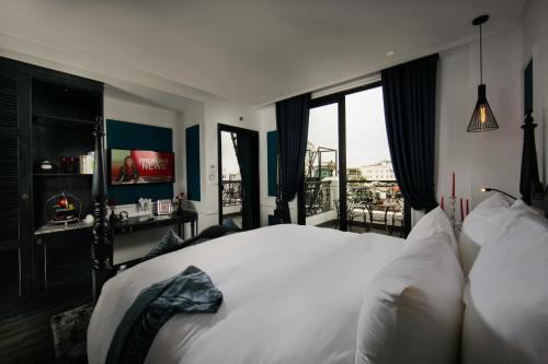 a bedroom with a large white bed and windows at JM Marvel Hotel & Spa in Hanoi