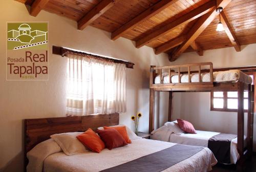 two bunk beds in a room with wooden ceilings at Hotel Posada Real Tapalpa in Tapalpa