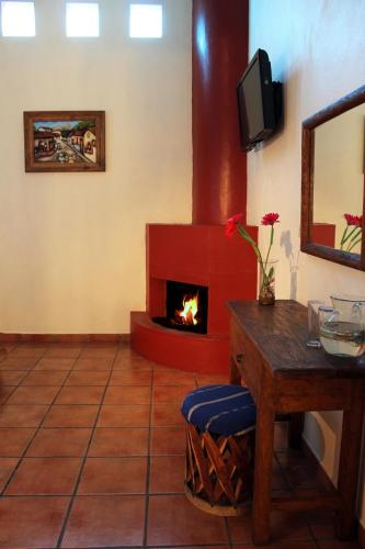 a living room with a fireplace and a table at Hotel Posada Real Tapalpa in Tapalpa