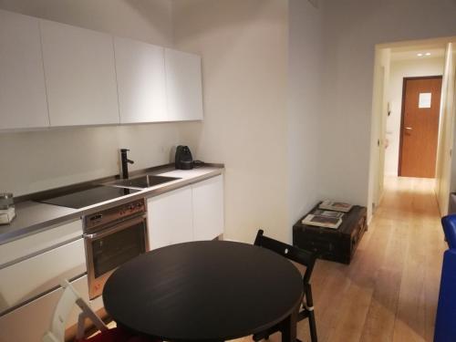 uma cozinha com uma mesa, um lavatório e um fogão em Appartamento Vitruvio42 em Milão