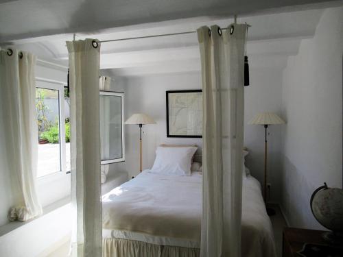 a bedroom with a bed with curtains and a window at Casa Blanca in Altea