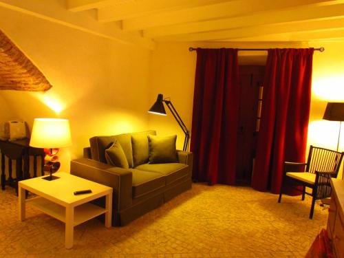 a living room with a couch and red curtains at Casa da Rua Nova in Castelo de Vide
