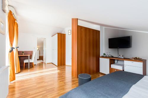 a bedroom with a bed and a desk with a television at Villa Nada in Lovran