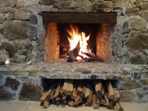 a brick fireplace with a fire in it at Recinto Natural SEMUK in Zacatlán