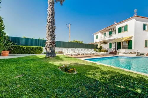 a house with a swimming pool and a palm tree at Bougainvilleas Villa - Private Pool and Parking, Nearby Beach in Altura
