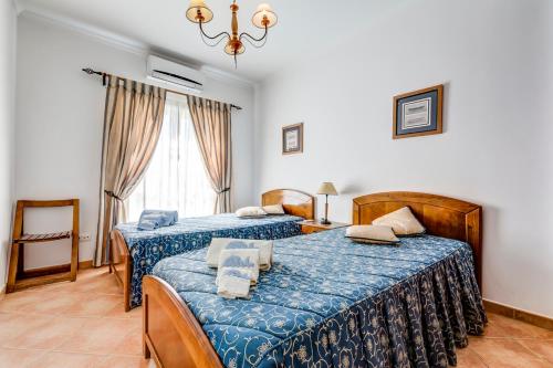 a bedroom with two beds and a window at Bougainvilleas Villa - Private Pool and Parking, Nearby Beach in Altura