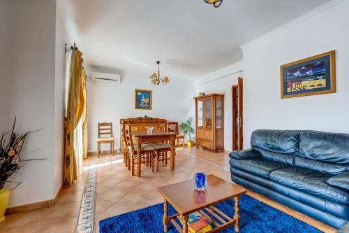a living room with a couch and a table at Bougainvilleas Villa - Private Pool and Parking, Nearby Beach in Altura