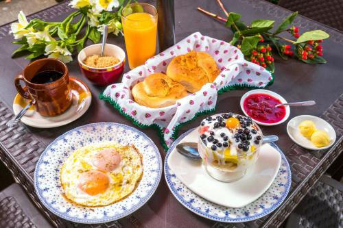 a table with plates of food and cups of coffee at Hostal Riviera Sucre in Otavalo