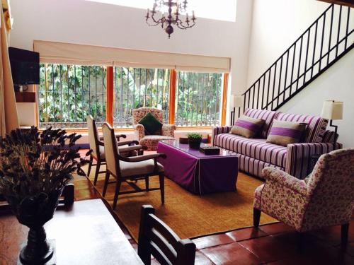 a living room with a purple couch and chairs at Casa Pixan in Malinalco