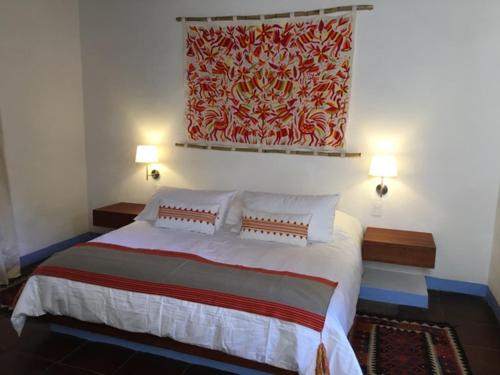 a bedroom with a large bed with two pillows at Casa Pixan in Malinalco
