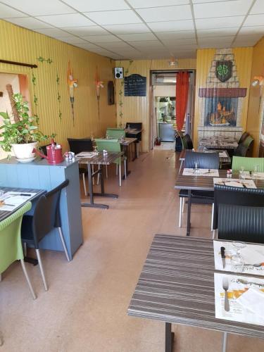 a restaurant with tables and chairs in a room at Chez les chtis de vayrac in Vayrac