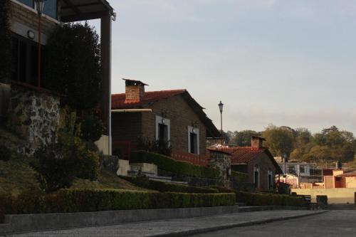 a row of houses on a street next to a road at Hotel y Cabañas una Cosita de Zacatlán in Zacatlán