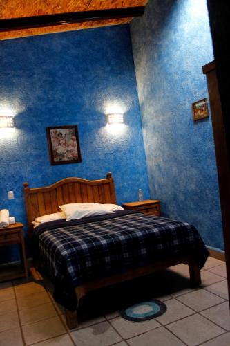 a bedroom with blue walls and a bed in a room at Hotel y Cabañas una Cosita de Zacatlán in Zacatlán