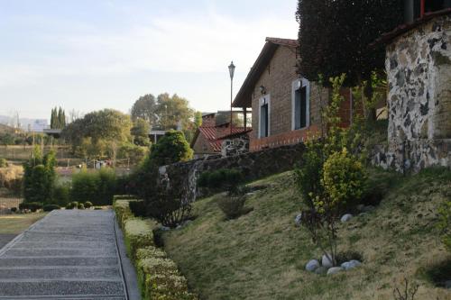 a house with a walkway next to a building at Hotel y Cabañas una Cosita de Zacatlán in Zacatlán
