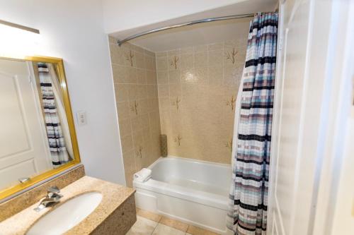Countryside Inn في كينغستون: حمام مع حوض ومغسلة وحوض استحمام