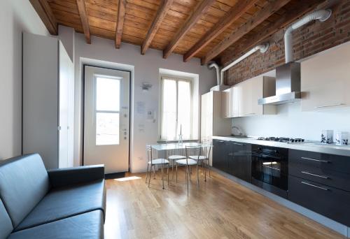 eine Küche mit einem Sofa und einem Tisch in der Unterkunft La Maison del Capestrano in Mailand