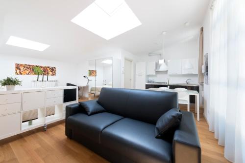 a living room with a black couch and a kitchen at La Maison del Capestrano in Milan