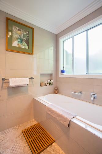 a white bathroom with a tub and a window at Armidale Cottage on Barney - House 2 in Armidale