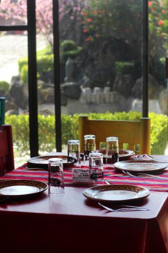 a table with plates and glasses on top at Hotel y Cabañas una Cosita de Zacatlán in Zacatlán