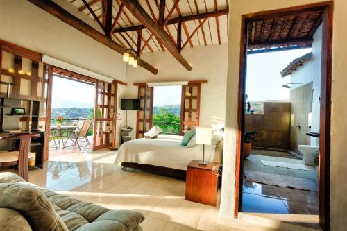 a bedroom with a bed and a living room at Casa Bari La Antigua in Barichara