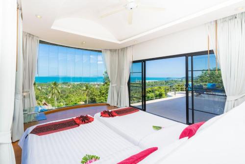 a bedroom with a bed with a view of the ocean at White Stone - Luxurious Sunset View 4 Bed Pool Villa in Nathon