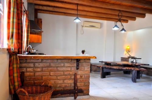 cocina con encimera de ladrillo y mesa en Complejo Abaurrea en Mendoza