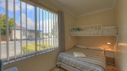 ein Schlafzimmer mit einem Bett und einem großen Fenster in der Unterkunft Dubbo Midstate Motor Park in Dubbo