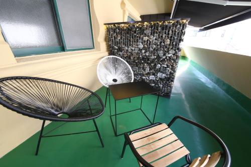une chambre avec deux chaises, une table et un ventilateur dans l'établissement Soho Hotel, à Busan