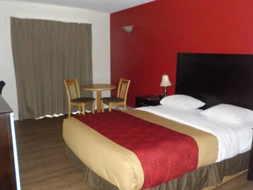 a hotel room with a bed and a table and chairs at Econolodge Vernon in Vernon